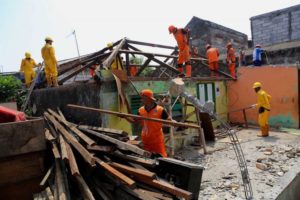 Pasukan pelangi saat menghancurkan bangunan rumah warga untuk program bedah rumah di Jalan Cilincing Lama, Cilincing, Jakarta Utara, Senin